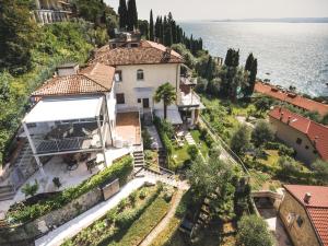 an aerial view of a house on a hill next to the water at Residence La Mignon Oleandri in Torri del Benaco