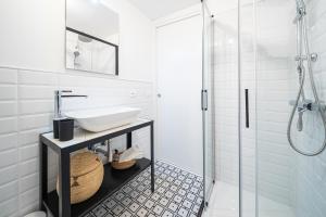 a white bathroom with a sink and a shower at Via Marconi B&B in San Vito al Tagliamento