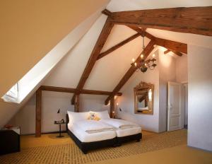 una camera da letto con letto bianco in mansarda di Romantik Hotel de L'Ours a Sugiez