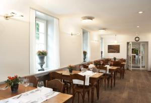 una sala da pranzo con tavoli e sedie in legno di Romantik Hotel de L'Ours a Sugiez