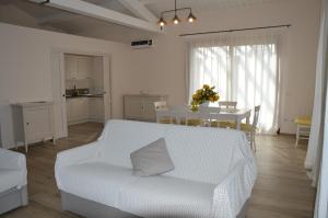 een woonkamer met een witte bank en een tafel bij Le Bozze -Villa Jenny con WI-FI, posto auto, piscina a sfioro a Castagneto Carducci in Castagneto Carducci