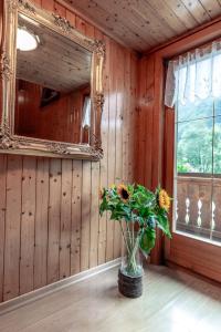 a mirror and a vase with flowers in a room at Vroni Höcher in Schruns