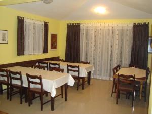 a dining room with tables and chairs and curtains at Pansion Ljubica in Međugorje