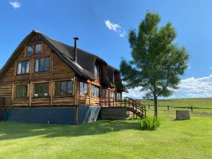 
a large house with a large window overlooking a lake at Khotso Lodge & Horse Trails in Underberg
