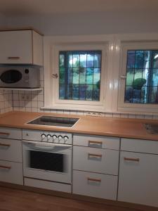 a kitchen with white cabinets and a stove top oven at Ferienwohnung am Ölsbach in Mudersbach