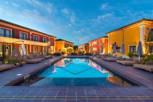 Villas for 4 or 6 Adults in Therma Village - Private Beach & Free Parking في كرانيفو: مسبح في ساحة مع كراسي ومباني