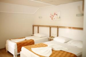 een kamer met twee bedden en een tafel erin bij Özhan Hotel in Antalya