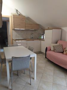 uma cozinha e sala de estar com uma mesa e um sofá em La mansarda della luna em Pietra Ligure