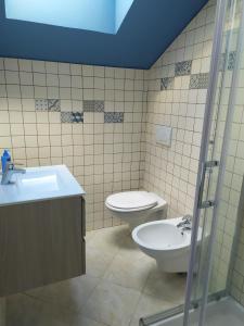 uma casa de banho com um WC, um lavatório e um chuveiro em La mansarda della luna em Pietra Ligure