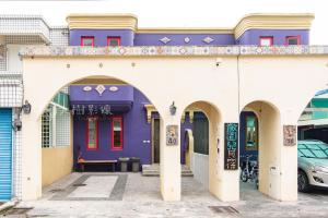 a purple and white building with arches at Arch Villa in Hualien City