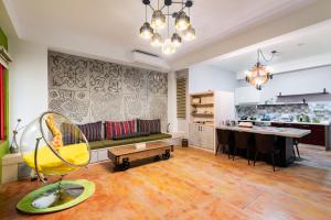 a living room with a yellow chair and a kitchen at Arch Villa in Hualien City