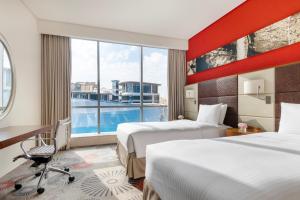 a hotel room with two beds and a large window at Crowne Plaza Doha - The Business Park, an IHG Hotel in Doha