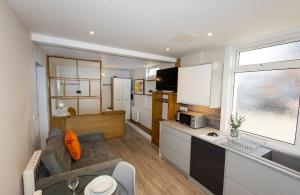 a kitchen and living room with a couch and a sink at Cosy Studio in Central Reading in Reading