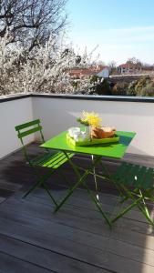 a green table and a chair on a balcony at Mimosas in Andernos-les-Bains