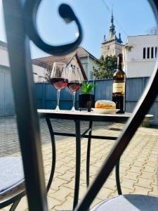 錫吉什瓦拉的住宿－Central Amelie Apartment，一张桌子,配有酒杯和一瓶葡萄酒