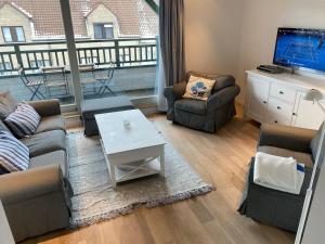 a living room with a couch and chairs and a tv at Appartement 3 Chambres A Koksijde in Koksijde