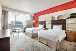 a hotel room with two beds and a desk at Crowne Plaza Doha - The Business Park, an IHG Hotel in Doha