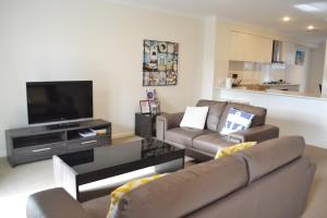 - un salon avec deux canapés et une télévision à écran plat dans l'établissement North Coogee Beach House, à Fremantle