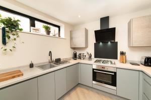 a kitchen with white cabinets and a stove top oven at Poole Quay Sea View with Parking in Poole