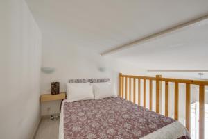 a bedroom with a bed and a wooden staircase at Logis Andraud Studios in Saint-Émilion