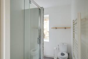 a bathroom with a glass shower with a toilet at Logis Andraud Studios in Saint-Émilion