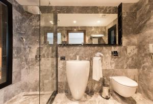 a bathroom with a toilet and a glass shower at Zeniva Hotel in Izmir