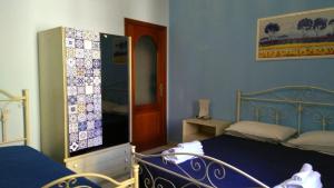 a bedroom with a blue bed and a tv at B&B Da Nonna Rita in Bagnara Calabra