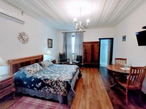 a bedroom with a bed and a table and chairs at Tiradentes Pousada Ramalhete in Tiradentes