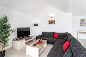 a living room with a gray couch and red pillows at Villa Rossa - Villas Now - LH215 By Villas Now Ltd in Playa Blanca
