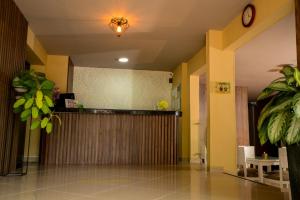 a lobby with a bar with a clock on the wall at Hotel Prado 34 West in Bucaramanga