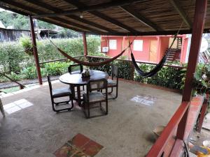 un patio con mesa, sillas y hamaca en Posada turística Quenari Wii, en Mitú