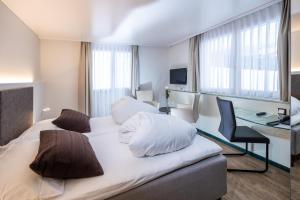ソーレンベルグにあるHotel Rischliのベッドとデスクが備わるホテルルームです。