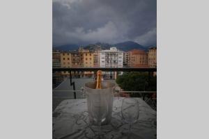 una bottiglia in una tazza sul tavolo sul balcone di Sunset Home a Ventimiglia
