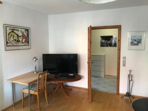 uma sala de estar com uma mesa e uma televisão em Ferienwohnung Hanns em Kiel