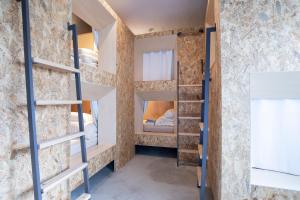 a room with bunk beds in a brick wall at HafH Nagasaki SAI in Nagasaki