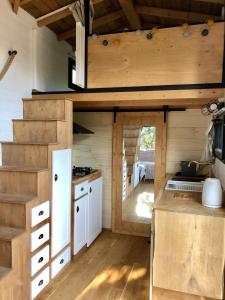 a kitchen in a tiny house with wooden walls at Spa Les Jardins De Chiron Lodges et Tiny House dans le sud in Sauve