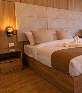 a bedroom with a large bed and a night stand at Nine Pyramids View Hotel in Cairo