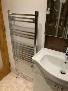 Un baño con lavabo blanco y ducha. en Dove Cottage (Annex), en Workington