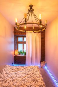 a bedroom with a bed and a chandelier at W sercu Srebrnej Góry in Srebrna Góra