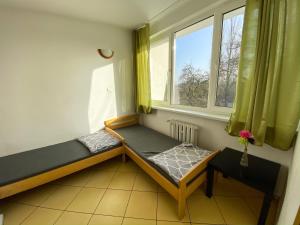 a small room with two beds and two windows at Ośrodek Wczasowy HELIOS in Jastrzębia Góra
