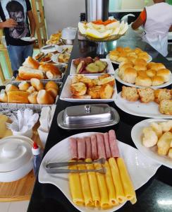 un lungo tavolo con piatti di cibo sopra di TERESINA HOTEL a Teresina
