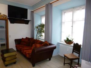 a living room with a brown couch and two windows at Lucky Home Sissi Appartment in Füssen