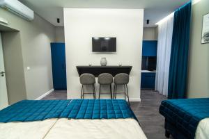 um quarto com duas camas e uma mesa com duas cadeiras em Apartments Azzurro Sarajevo em Sarajevo