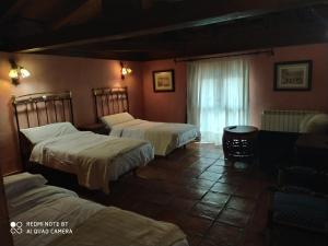 a room with three beds and a window at la felicidad de la tierra in Torija