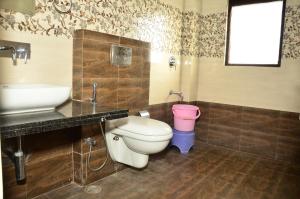 baño con aseo, lavabo y cubo rosa en Brahma Paradise , A heritage haveli, en Pushkar 55 fotos más