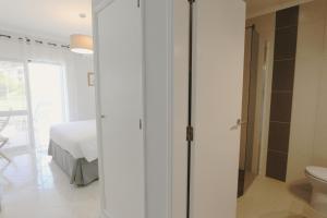 ヴィラモウラにあるPinhal do Golf - Clever Detailsの白いベッドルーム(ベッド1台、バスルーム付)