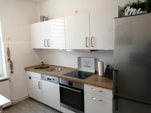 a kitchen with white cabinets and a stainless steel refrigerator at Steinmarner Bude in Cuxhaven