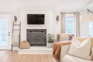 a living room with a fireplace with a flat screen tv at Stylish & Spacious Home Near ATL in Jonesboro