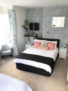 1 dormitorio con 1 cama grande con almohadas rosas en Doriam Guest House, en Bridlington