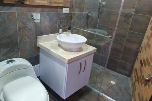 a bathroom with a white sink and a toilet at Hermoso apartamento con vista al lago in Paipa +8 photos